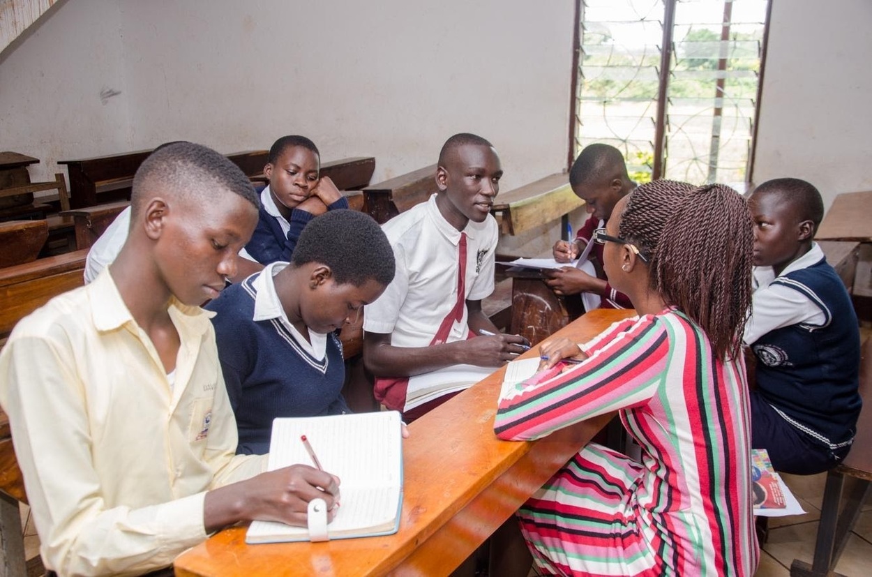 A small group of students at their desks huddled around a lecturer.