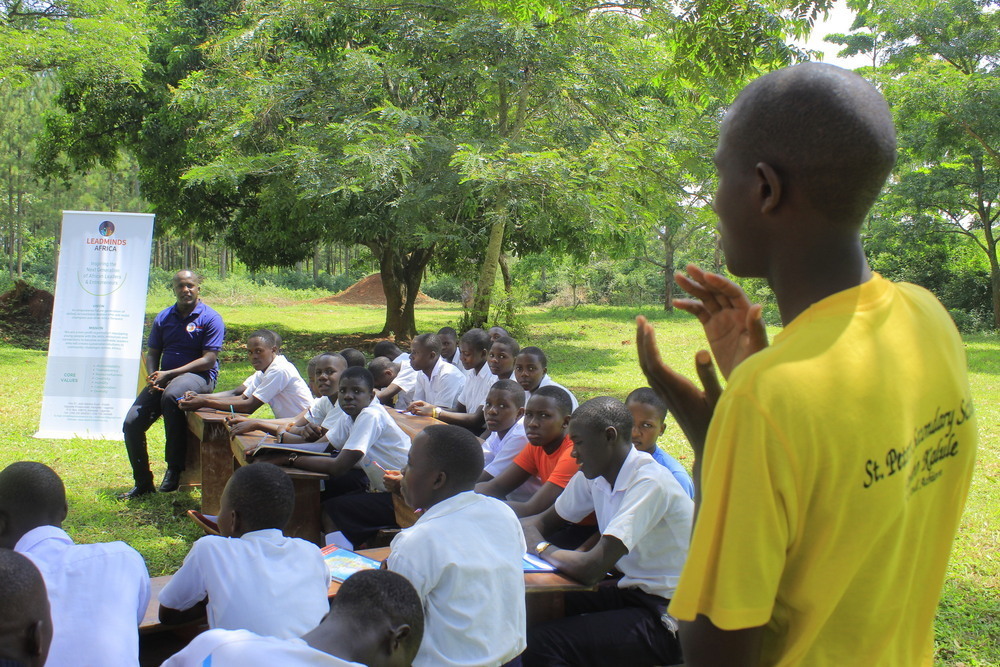 A student standing to speak in an outdoor classroom.