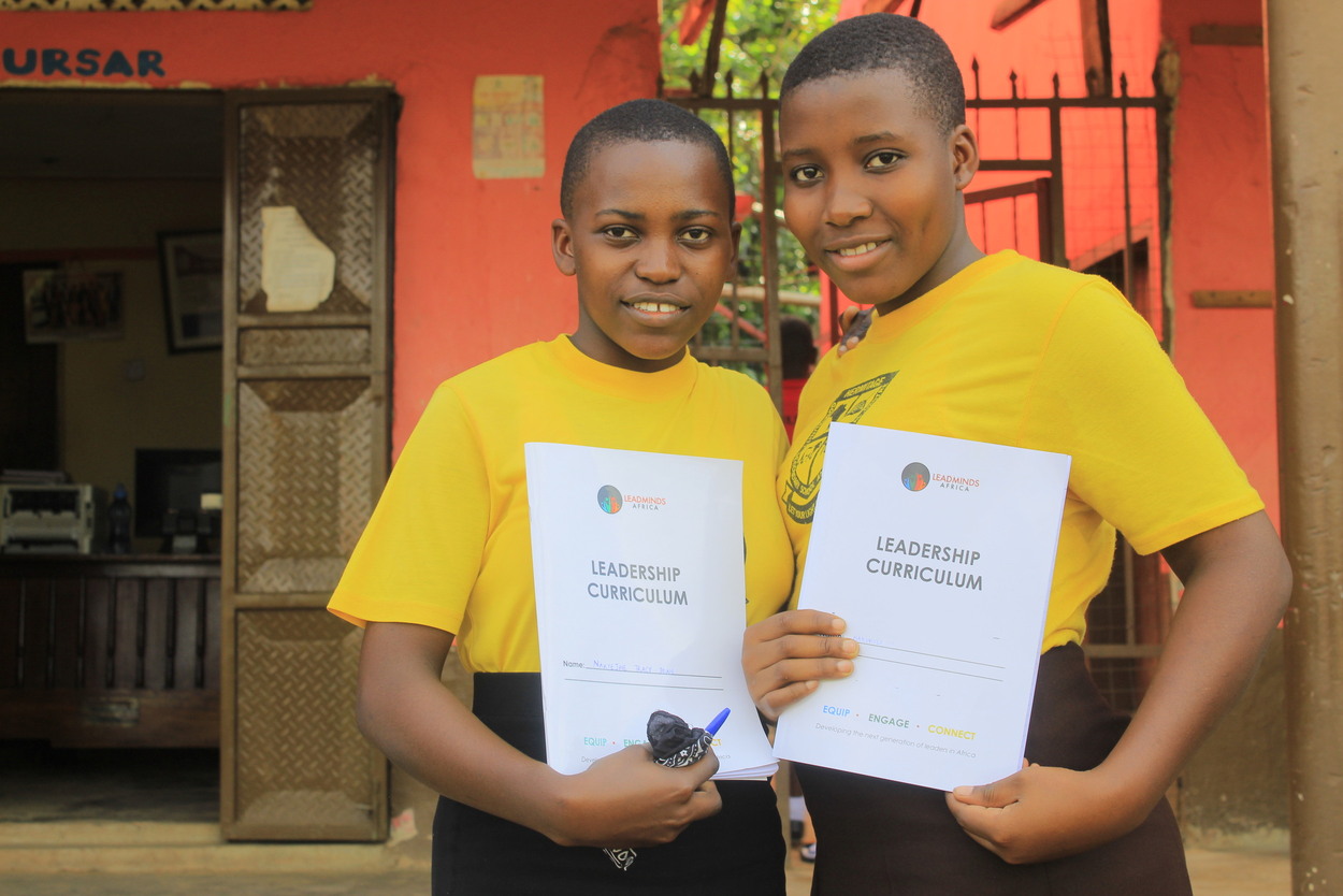 Two young students showing off their Leadership Curriculum materials.